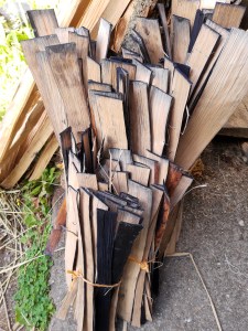 Three bundles of oak leaned up. In the front the shortest bundle 2  is approximately 18 inches high, behind it the taller second bundle about 3 feet high. At the back the tallest bundle is about 5 feet high.